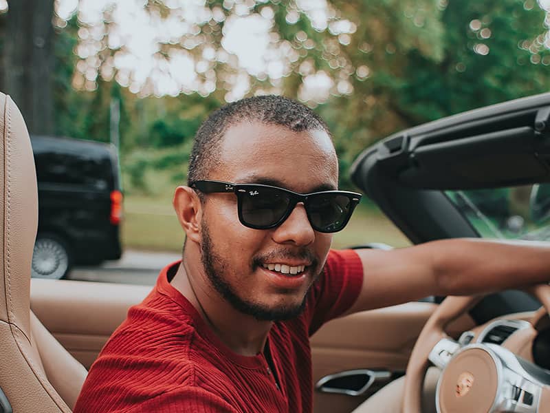 hombre conduciendo y usando gafas de sol negras
