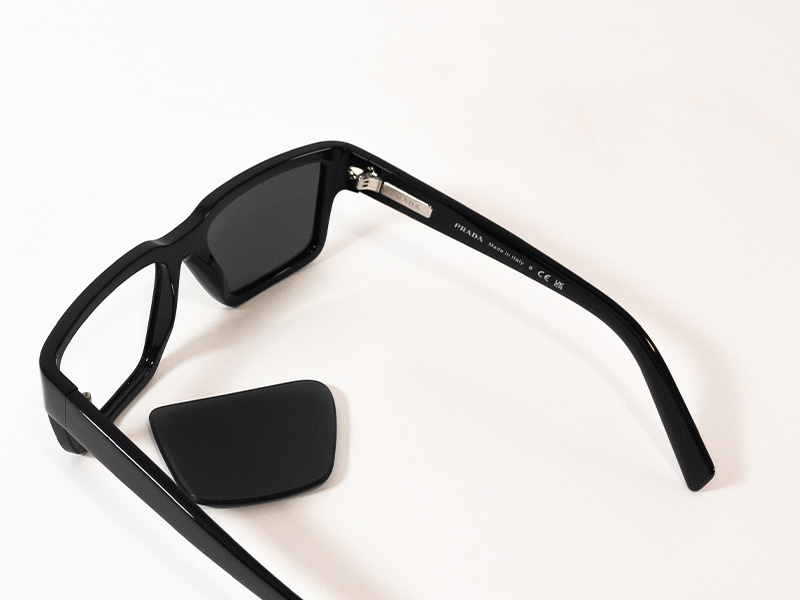 Zerlegte Prada-Sonnenbrille mit entferntem Prada-Glas und Details am Innenbügel, mit hervorgehobenen Echtheitsmarkierungen und einfachem Glaswechsel