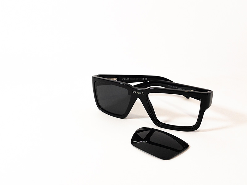 Schwarze Prada-Sonnenbrille mit einem entfernten Glas. Es wird gezeigt, wie man ein Prada-Ersatzglas einsetzt, um die authentische Fassung wiederherzustellen